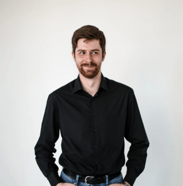 bearded male in black shirt with mischievous look in his eyes